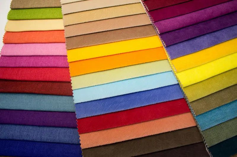 Mostruário de tecidos coloridos sobre uma mesa