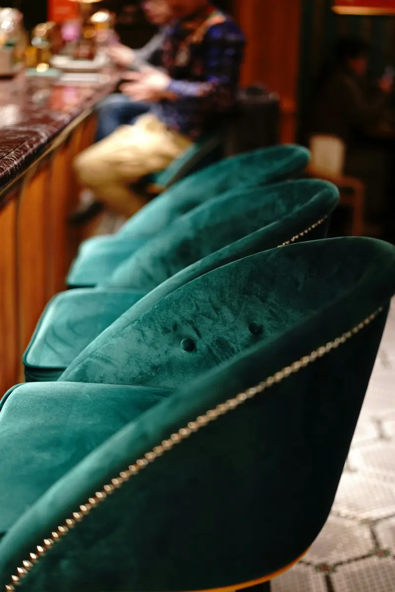 Poltronas de veludo verde com acabamento de tachas
